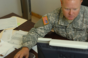 Guantanamo Bay, Cuba. - 1st Lt. Shane T. Lauritzen, a New Mexico Army National Guardsman with Joint Task Force Guantanamo's Logistics Directorate Motor Pool Detachment looks over vehicle contracts as part of his daily routine, July 8, 2008. The Motor Pool manages the distribution and maintenance of all Government issue vehicles for the JTF. (JTF Guantanamo photo by Navy Petty Officer 3rd Class Kleynia R. McKnight)