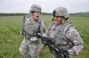 A 189th Infantry Brigade Observer Controller/Trainer yells out instructions to a Provincial Reconstruction Team member during a stress shoot lane of their training. Stress Shoot is a lane that Warriors have to low and high crawl, run, and drag a 100 pound sled up a hill and then be able to fire their weapon after being tired and wore out. (U.S. Army photo by Spc. Jeff Field)