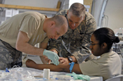  Sen. Airman Albert Lamboy gives Air Force Staff Sgt. Eunice Luster an IV as Senior Medic Master Sgt. Ken Gestring watches over during a combat lifesaver course held at Camp Atterbury, Ind., May 28. (U.S. Army photo by Spc. John Crosby) 
