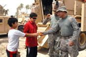 BAGHDAD – Staff Sgt. Adam Sanchez (right), of Alexandria, La., gives his yo-yo to Ali and his brother, Hamza, outside of Salam Palace in Baghdad, June 6. (U.S. Army Photo by Scott Flenner, 225 Eng. Bde., 1st Cav. Div., MND-B)