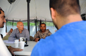  USAID field manager Brad Bessire (left) and Capt. Darrack Lee speak with a local provincial leader to discuss election security operations Tuesday, June 9, 2009, during a training exercise at Camp Atterbury, Ind. Both men are members of the Afghanistan Provincial Reconstruction Team Parwan, a civilian/military team scheduled to deploy this summer to Afghanistan. (U.S. Army photo by Sgt. Robert G. Cooper III) 
