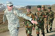 Sgt. 1st Class Roger Krause, 1st Battalion, 183rd Regimental Training Institute, Virginia National Guard, shows a group of Tajik soldiers how to use a hand and arm signal in order to form a wedge formation during the U.S.-Tajikistan NCOPD field training exercise, Jan 30. (Photo by Staff Sgt. Alex Licea, U.S. Army Central Public Affairs)