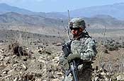 A Soldier from C Company, 1-162 Field Artillery Regiment, Puerto Rico National Guard stands guard while U.S. Soldiers talk with Afghan National Police commander of the Bara border check point, Gorbuz District, Khowst Province, Afghanistan, March 22. (U.S. Army photo by Staff Sgt. Isaac A. Graham, 982nd Combat Camera Company)