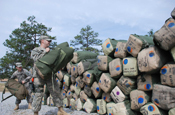 Arkansas Pfc. Joshua Jackson (front) and Sgt. Scott Willette, both of Company D, 1st Battalion, 153 Infantry Regiment of the 39th BCT, add their bags to the stack in March 2008 as segments of the brigade begin preparing to move forward from Camp Shelby, Miss., to a base of operations in Kuwait. Groups of Arkansas' Soldiers are expected to begin leaving for Kuwait in the coming days. The Soldiers will spend a couple of weeks there training and getting acclimated to dessert conditions before moving on to their deployment stations in Iraq. (Photo by: Maj. Craig Heathscott, Arkansas National Guard).