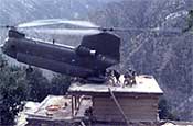 A Pennsylvania Army National Guard CH-47D Chinook helicopter from Company G, 104th Aviation, lands on the roof of a house in Nuristan Province, Afghanistan to pick up suspects during Operation Mountain Resolve in November 2003.