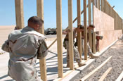 A team of carpenters from Headquarters and Headquarters Company, 20th Engineer Brigade, Fort Bragg, N.C., set the frame of a maintenance bay they are building for the company's motor pool May 3, 2005, at Camp Victory, Iraq. (U.S. Army photo by Sgt. Michael J. Carden)
