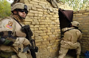 SPC Dominic Palammo from the 940th MP Company out of Walton Kentucky, searches a small room ,while MAJ Lawendowski from the Alaskan National Guard provides security during a joint patrole, in the town of Al Hillah, Iraq on May 14 2005. (U.S. Army Photo by SGT Hamilton, Arthur)