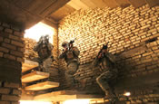 Soldiers from the Illinois Army National Guard's 2nd Platoon, 2nd Battalion, 130th Infantry Regiment, play it safe as they head up the staircase of an abandoned building June 23, 2005 in Abu Ghraib, Iraq. (U.S. Army photo by Spc. Jeremy D. Crisp.)