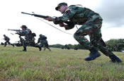 FORT MAGSAYSAY, Philippines -- U.S. Army Staff Sergeant Dean Bliablias from Charlie Company, 1-185 Infantry Battalion along with both service members of the Armed Forces of the Philippines and U.S. Army simulate war tactics on a Modified Ranger Field, Feb. 23, 2006. Both countries are participating in the Balikatan 2006 exercise. (U.S. Air Force photo by Senior Airman Jacqueline Kabluyen)