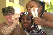 Army SGT Erin Hyland, a 91WM6 Army Nurse with the 729th Forward Support Battalion Maryland Army National Guard entertains local kids waiting on line to be treated during a Medical readiness exercise (MEDRETE) in Anaimatejed School in Barahona, Dominican Republic on March 22, 2006. New Horizons 06 is a humanitarian assistance project held in Barahona, Dominican Republic that will benefit the rural towns and populace with the construction of 4 clinics and basic medical care. NH06 is sponsored by U.S. Southern Command and executed by U.S. Army South alongside the Government of the Dominican Republic. (US Army Photo by Miguel A. Negron, GS-9)