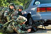 Army National Guard Soldiers from the 76th Brigade Combat Team take cover after being shot at by a rooftop 'sniper' during an exercise at the Muscatatuck Urban Training Center, Ind. (Photo by Sgt. Jim Greenhill)