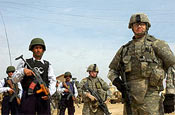 Cpl. William Parker of Redwood Falls, Minn., (right) and Spc. Brent Haataja of Menahga, Minn., both of Company B, 194th Combined Arms Battalion, Minnesota Army National Guard, pause before leading Iraqi Policemen to a checkpoint Feb. 15, in Anah, Iraq. Photo by Sgt. 1st Class Clinton Wood, 1/34 BCT PAO.