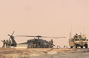 Exercise Granite Triangle - Pfc. Kevin Wheeler, of the 237th Military Police Company, pulls security at a landing zone while Soldiers from the 1159th Medical Company (Air Ambulance) circle above in a UH-60 Blackhawk helicopter in preparation for landing to pick up a simulated casuality during Exercise Granite Triangle at Fort Pickett, Va.