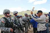 Oregon National Guard Soldiers, from B Company, 2nd Battalion, 162nd Infantry, Sgt. Brandon Hern (left), of Corvallis, and Pvt. 1st Class Geoffery Thoma (right), of Albany, simulate controlling a crowd of a villagers at a food distribution site during Distribution training Aug. 16, at Five Hills Training Center, near Ulaanbataar, Mongolia, for Khaan Quest 2006, UN peacekeeping exercise. (Photo by Spc. April L. Dustin, Oregon National Guard Public Affairs)
