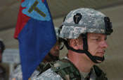 Front, Cpt. Steven Shaffer, commander, Task Force Falcon, 36th Infantry Division, Texas National Guard and in back, Spc. Lawrence Williams, TF Falcon, 36th Inf. Div., look during the transfer of authority ceremony at 10 a.m. on Jan. 18 at Camp Bondsteel, Kosovo.