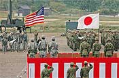Oregon National Guard and Japan Ground Self Defense Force troops salute the U.S. and Japanese flags during the Orient Shield opening ceremony Monday.
