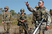 Sgt. Steven Tessitore, 2-162 mortar sergeant and resident of Corvallis shows members of Japan's 2nd Infantry Battalion, 1st Airborne Brigade how the United States Army sights in their mortars Oct. 19 in Japan. Along with showing the Japanese how the U.S. Army infantry operates, the Oregon National Guard Soldiers are also learning Japanese tactics during Orient Shield 2007. (Photo by Staff Sgt. Russell Bassett, 115th Mobile Public Affairs Detachment)