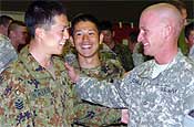 Pfc. Adam Comella (right), of Gresham shares a laugh with privates Akihiro Saito and Koji Hakado during the welcome party Monday evening. Many of Oregon National Guard Soldiers exchanged gifts with the Japanese soldiers during the party.