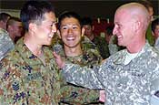Pfc. Adam Comella (right), of Gresham shares a laugh with privates Akihiro Saito and Koji Hakado during the welcome party Monday evening. Many of Oregon National Guard Soldiers exchanged gifts with the Japanese soldiers during the party.