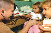 CPT Sean Stiltner, a field surgeon from the Ohio Army National Guard, examines a Honduran girl from the village of Aldea Orotinos during the medical readiness training exercise portion of Operation New Horizons. June 2, 2006 (by Cpl. Benjamin Cossel)