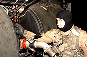 Colorado Guardsman Sgt. Brian Cooper, Company B, 2nd Battalion, 135th Aviation Regiment, preps a CH-47 Chinook helicopter so it can be refueled. He and fellow crewmembers performed a cargo supply mission recently flying ammunition and fuel cans to several bases in Baghdad, Iraq. (U.S. Army photo by Staff Sgt. Lorin T. Smith)